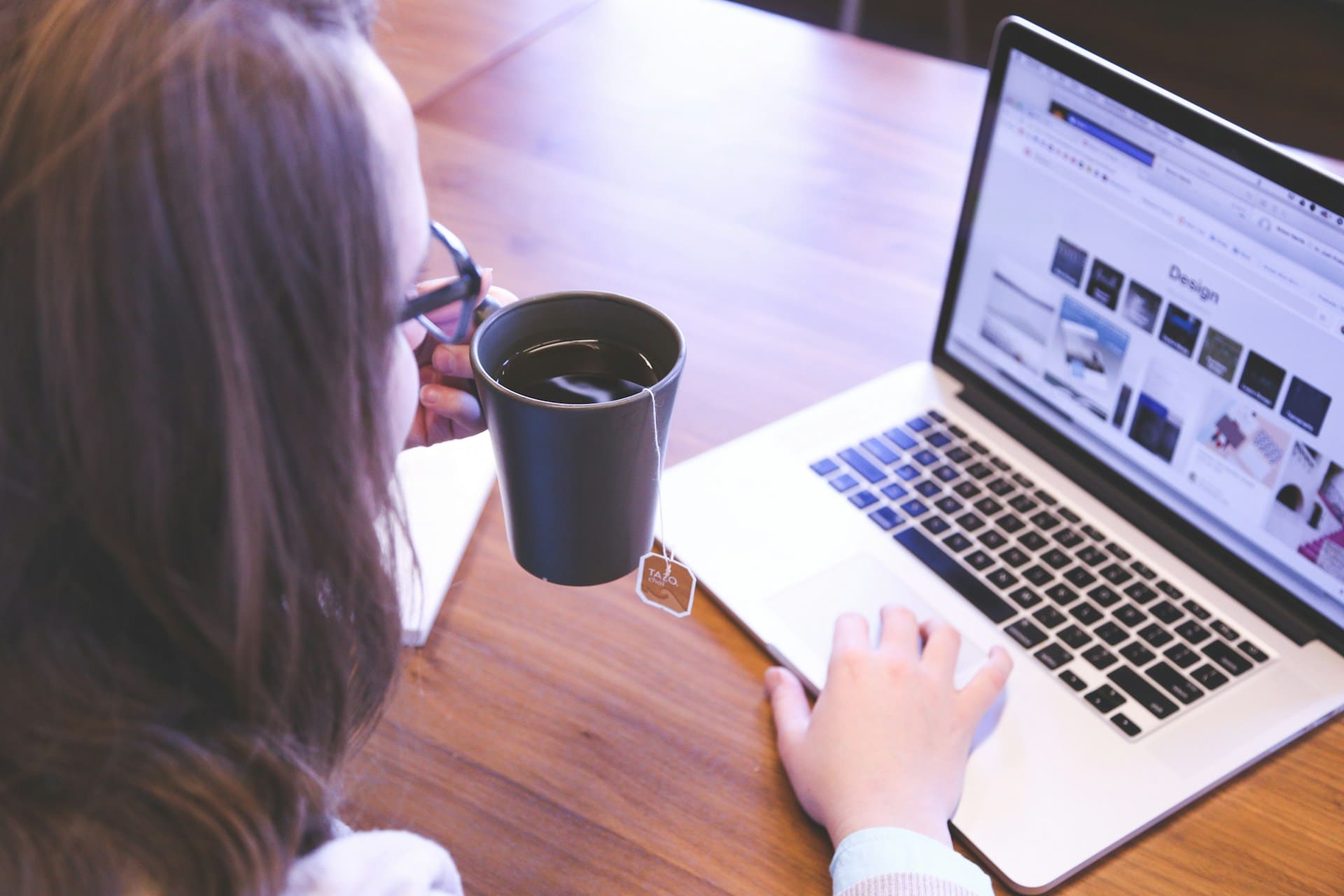 Person with cup of tea sitting at computer
