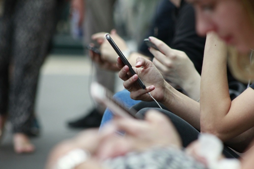 People on a train using phones.